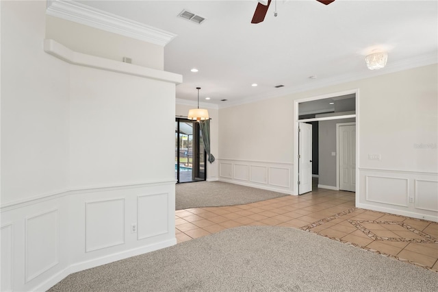 unfurnished room with tile patterned flooring, visible vents, a decorative wall, and crown molding