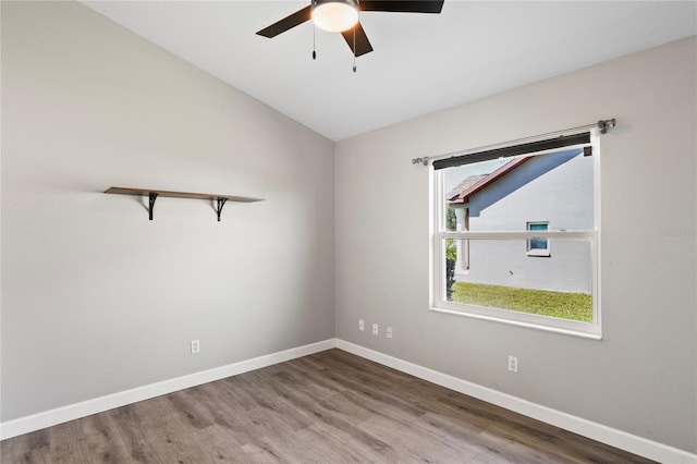 spare room with lofted ceiling, ceiling fan, baseboards, and wood finished floors