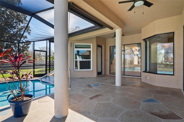 view of patio / terrace with ceiling fan, glass enclosure, and an outdoor pool