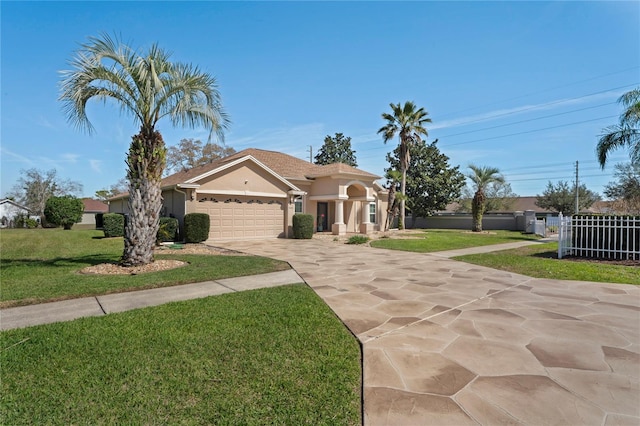 mediterranean / spanish home with a garage, concrete driveway, a front lawn, and stucco siding