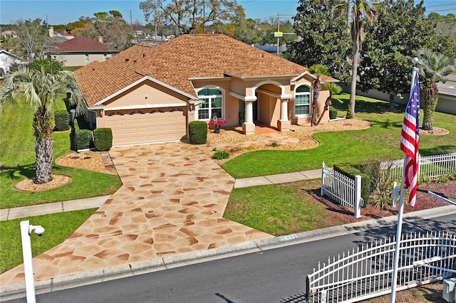 mediterranean / spanish home with driveway, a fenced front yard, an attached garage, a front yard, and stucco siding