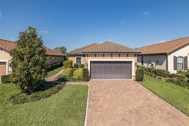 view of front facade featuring a tiled roof, a front lawn, decorative driveway, and stucco siding