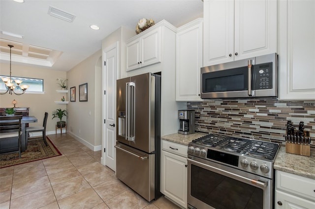 kitchen featuring white cabinets, stainless steel appliances, visible vents, and decorative backsplash