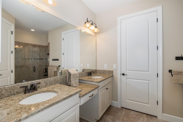 full bathroom featuring a stall shower, tile patterned flooring, vanity, and baseboards