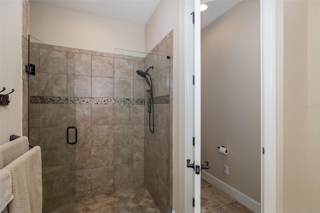 bathroom with a stall shower and baseboards