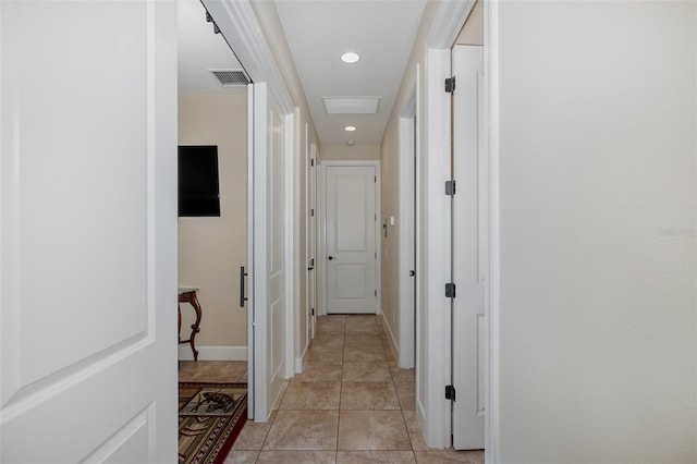 hall with light tile patterned floors, baseboards, visible vents, and recessed lighting