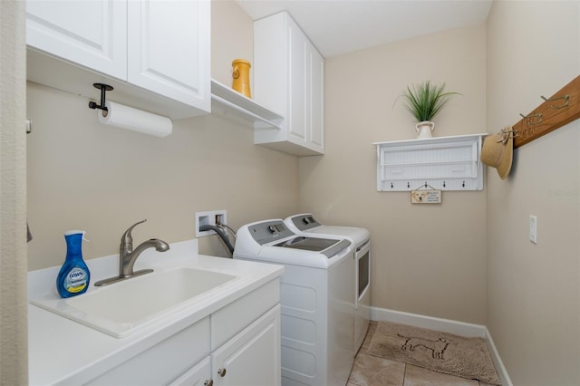 washroom featuring cabinet space, baseboards, washer and clothes dryer, tile patterned flooring, and a sink