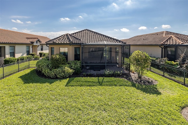 rear view of property with a fenced backyard, a lawn, a tiled roof, and stucco siding