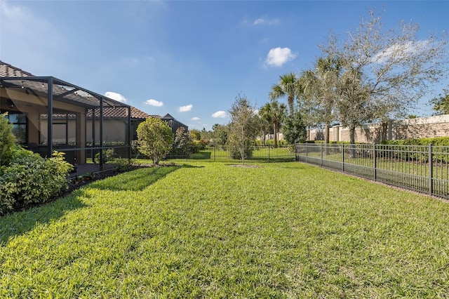 view of yard featuring a fenced backyard and a lanai