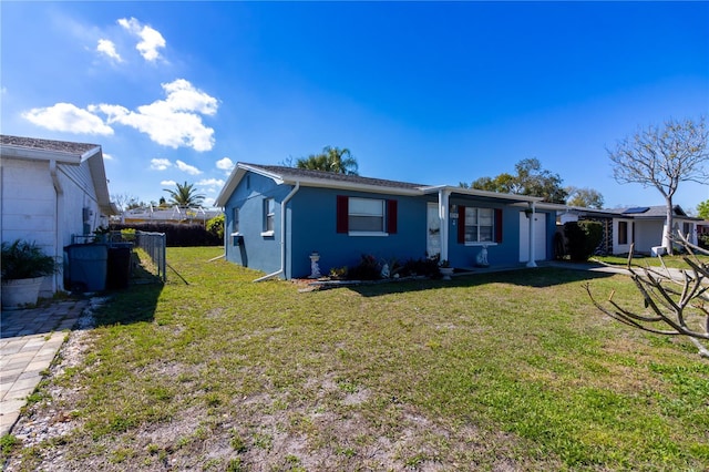 single story home featuring a front yard, fence, and stucco siding