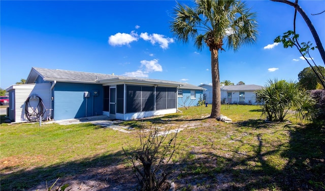 rear view of house featuring a sunroom, fence, and a yard