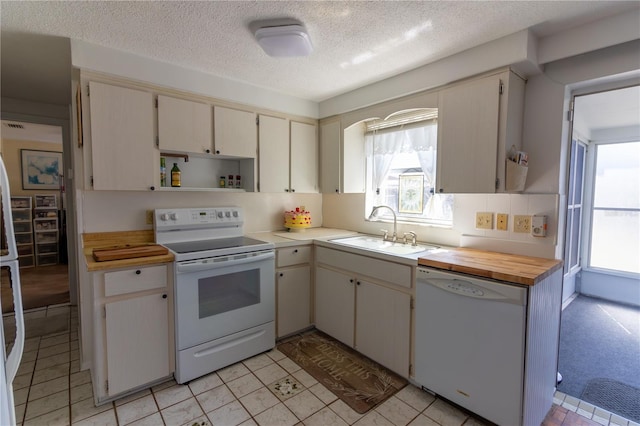 kitchen with white appliances, a sink, open shelves, and cream cabinetry