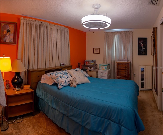 carpeted bedroom with visible vents and a textured ceiling