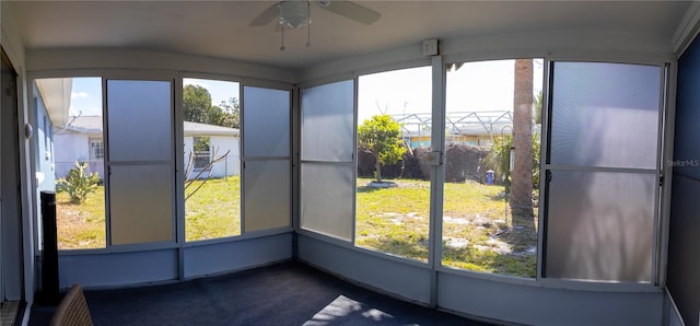 unfurnished sunroom featuring a wealth of natural light and a ceiling fan