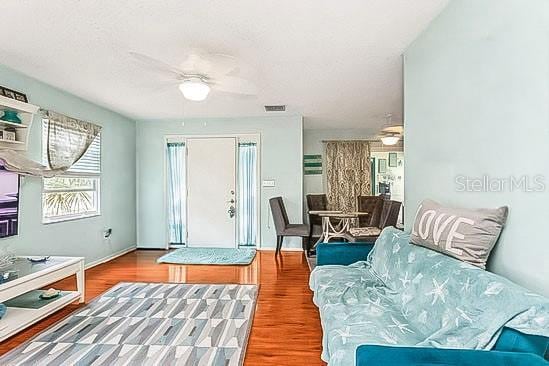 entrance foyer featuring baseboards, visible vents, a ceiling fan, and wood finished floors