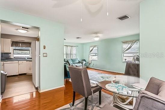 interior space with visible vents, ceiling fan, baseboards, and wood finished floors