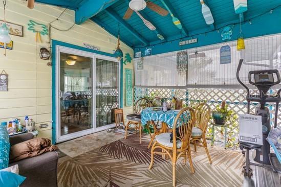 sunroom / solarium with a ceiling fan, a healthy amount of sunlight, and lofted ceiling with beams