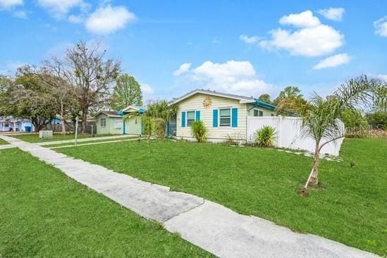 view of front of home with a front yard and fence