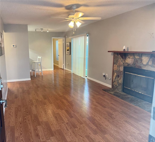 14736 Norwood Oaks Dr Unit 103, Tampa, FL 33613 - unfurnished living room with baseboards, a ceiling fan, wood finished floors, a textured ceiling, and a fireplace