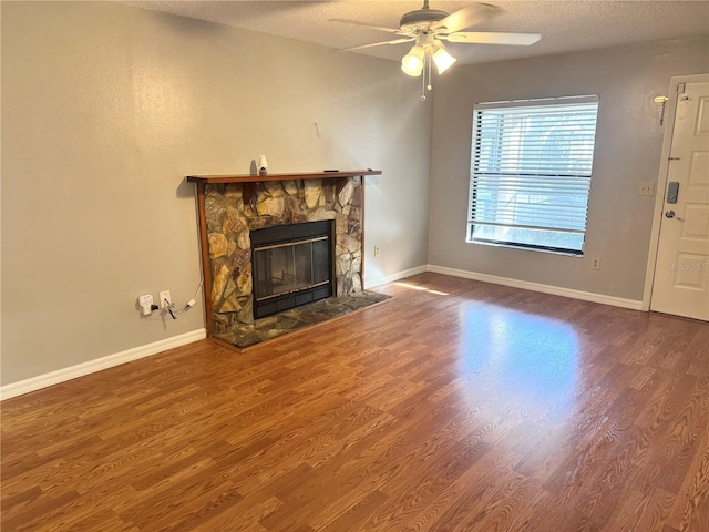 14736 Norwood Oaks Dr Unit 103, Tampa, FL 33613 - unfurnished living room with ceiling fan, a textured ceiling, wood finished floors, and a stone fireplace