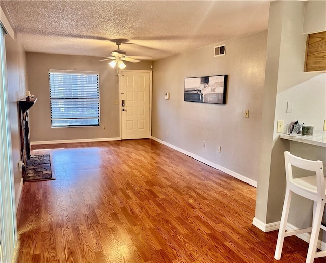 14736 Norwood Oaks Dr Unit 103, Tampa, FL 33613 - interior space featuring baseboards, visible vents, a ceiling fan, wood finished floors, and a textured ceiling