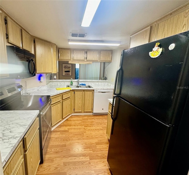14736 Norwood Oaks Dr Unit 103, Tampa, FL 33613 - kitchen with light wood finished floors, light countertops, visible vents, a sink, and black appliances
