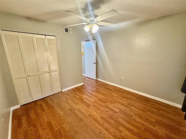 14736 Norwood Oaks Dr Unit 103, Tampa, FL 33613 - unfurnished bedroom featuring a closet, visible vents, baseboards, and wood finished floors
