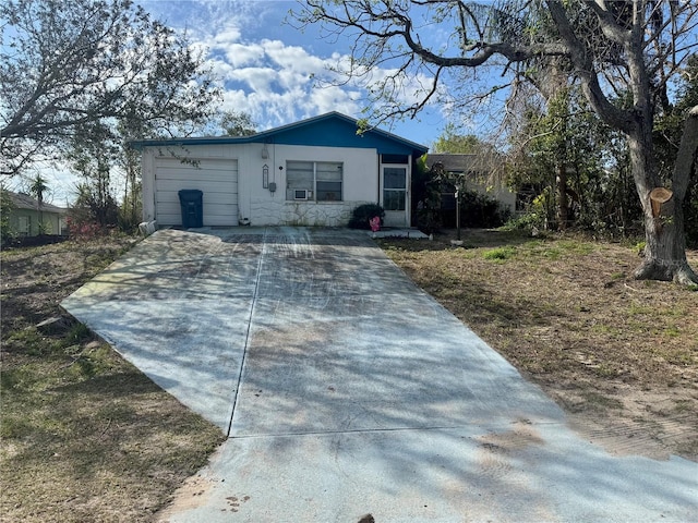 ranch-style house with an attached garage and concrete driveway