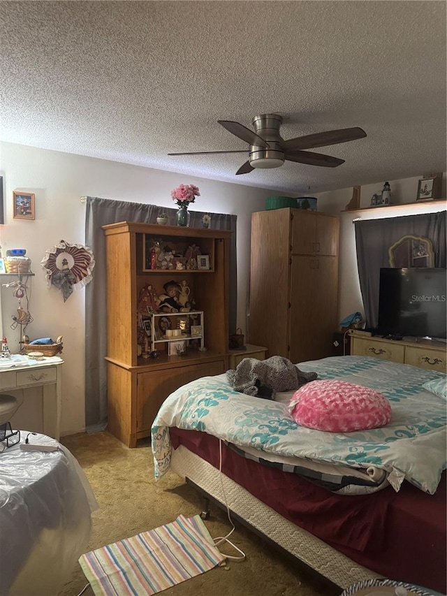 bedroom featuring a ceiling fan, light colored carpet, and a textured ceiling