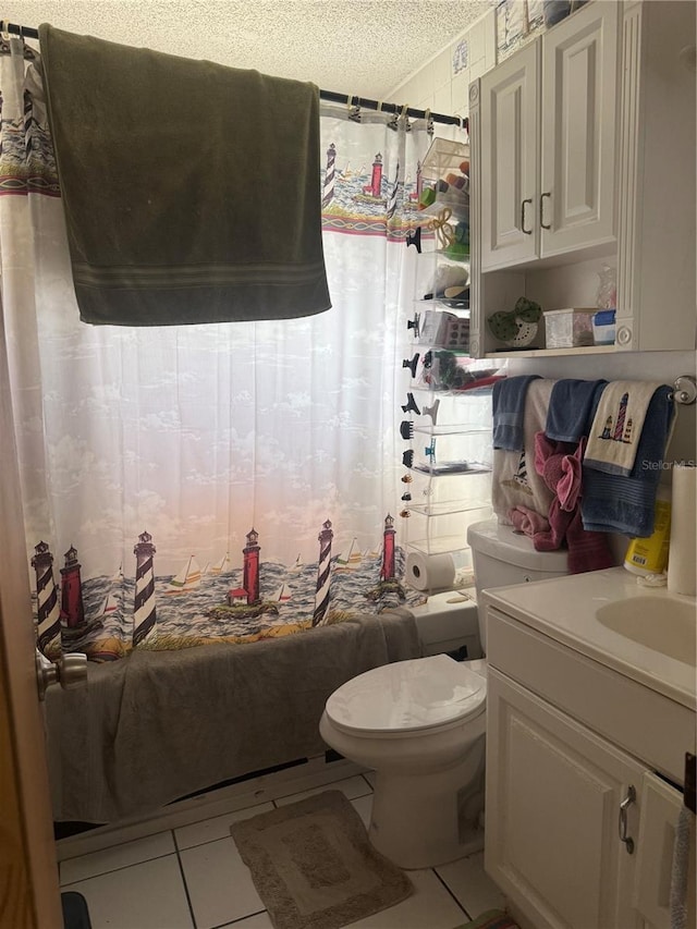 full bath featuring a textured ceiling, vanity, tile patterned flooring, and toilet