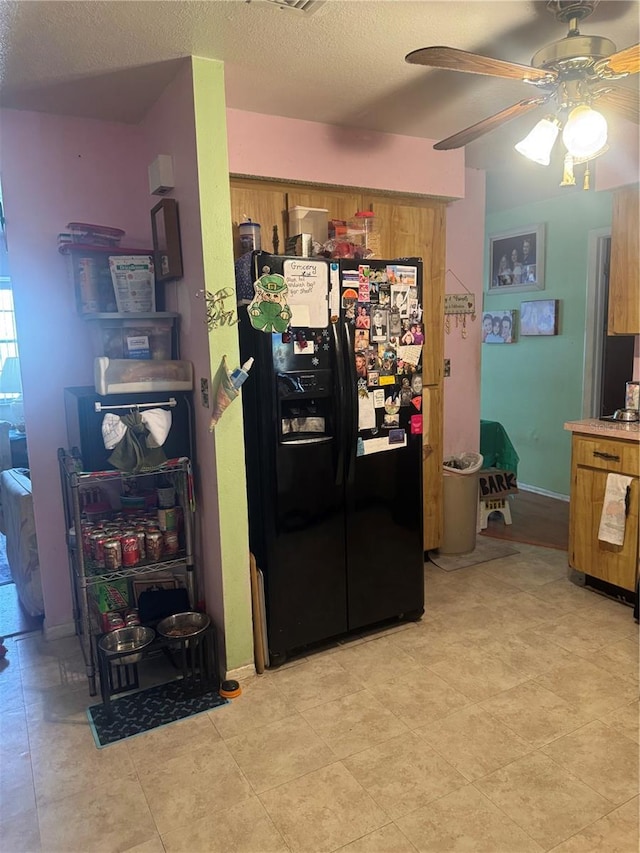 kitchen with ceiling fan, a textured ceiling, light countertops, brown cabinets, and black refrigerator with ice dispenser