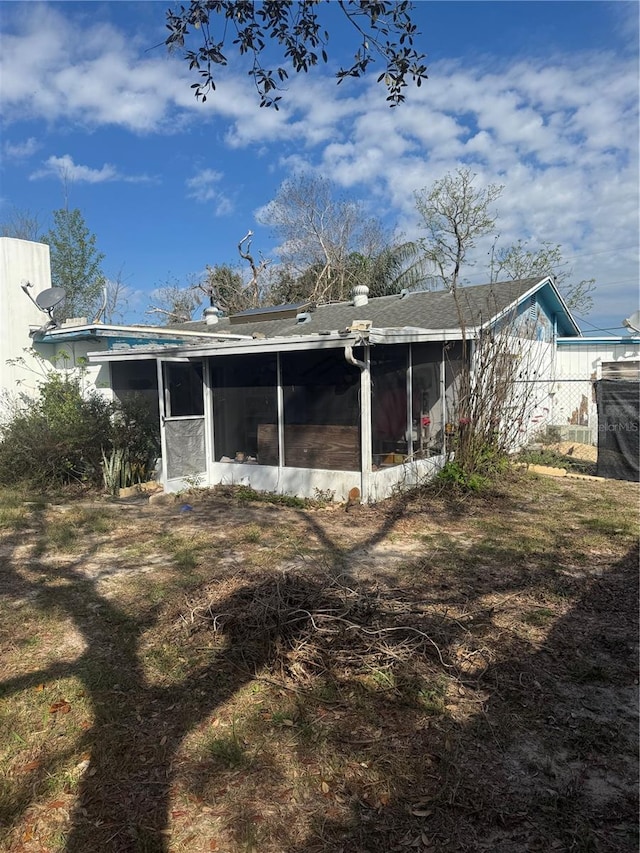 rear view of house featuring a sunroom