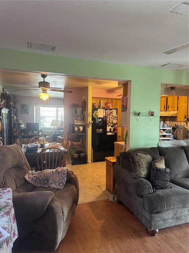 living area featuring visible vents, light wood-style flooring, and a ceiling fan