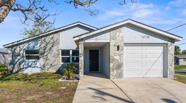 mid-century home with a garage, driveway, stone siding, and stucco siding