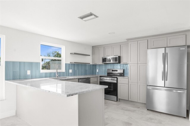 kitchen with open shelves, stainless steel appliances, gray cabinets, visible vents, and a peninsula