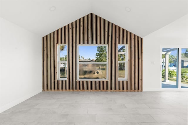 interior space featuring vaulted ceiling and baseboards