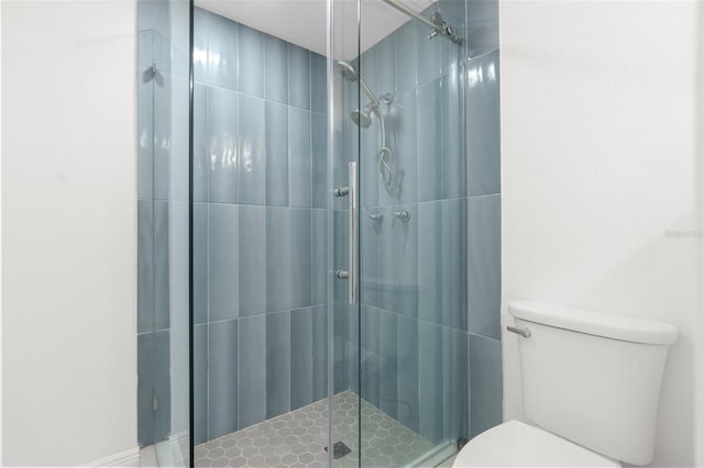 bathroom with a shower stall and toilet