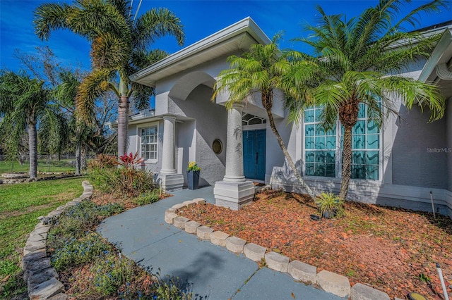 doorway to property featuring stucco siding