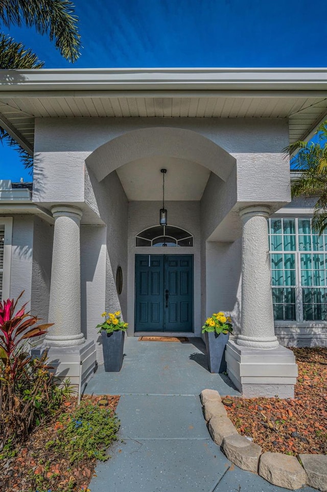 doorway to property featuring stucco siding