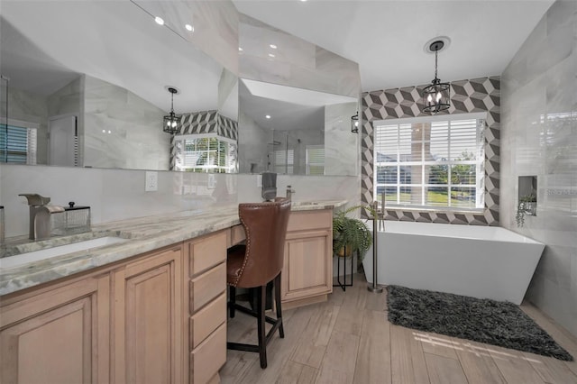 full bathroom with a freestanding bath, a stall shower, vanity, and tile walls