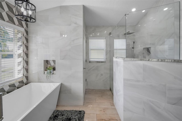 bathroom featuring a soaking tub, tile walls, and walk in shower