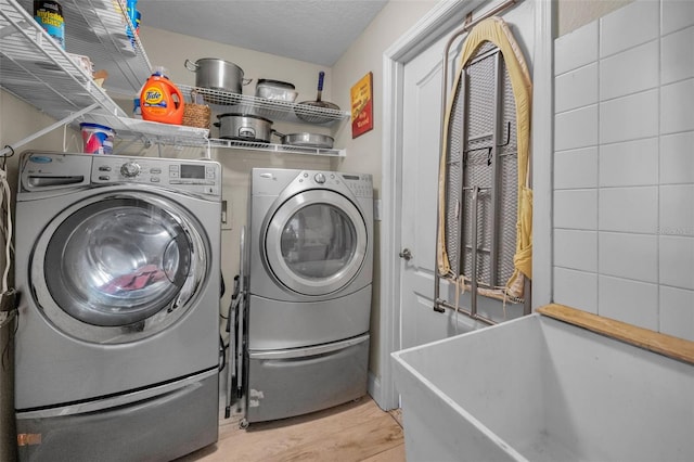 laundry area featuring laundry area, washing machine and dryer, and a textured ceiling