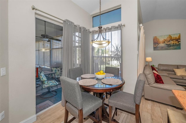 dining room featuring vaulted ceiling, ceiling fan, wood finished floors, and baseboards