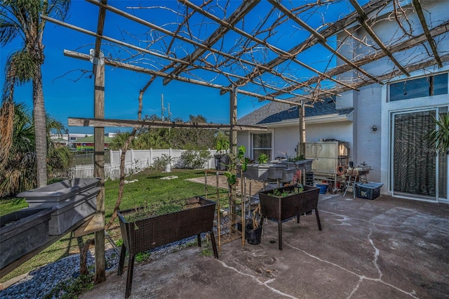 view of patio / terrace with a vegetable garden and fence