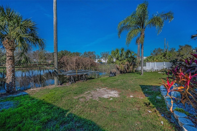 view of yard with a water view and fence