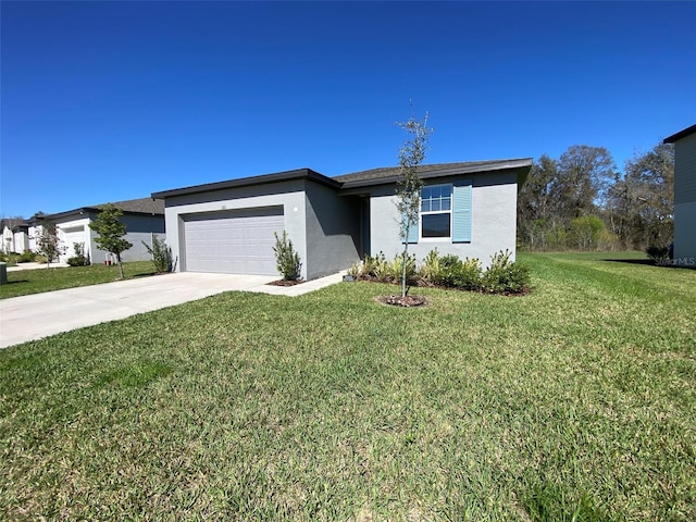 view of front of house featuring driveway, a garage, a front yard, and stucco siding