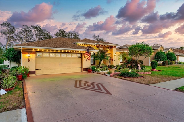 view of front of house featuring driveway, an attached garage, and stucco siding