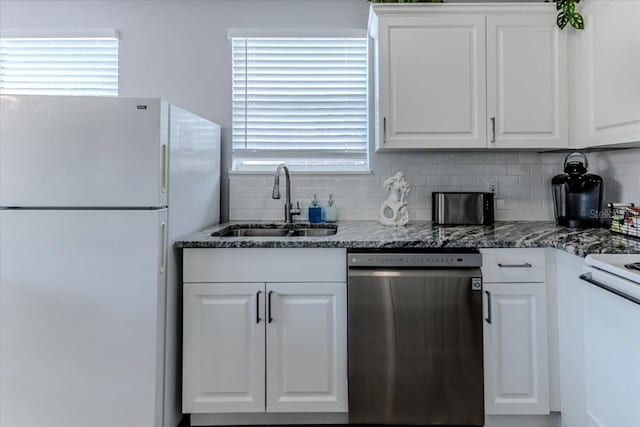 6183 Waverly Rd, Weeki Wachee, FL 34607 - kitchen with stainless steel dishwasher, freestanding refrigerator, a sink, and white cabinets
