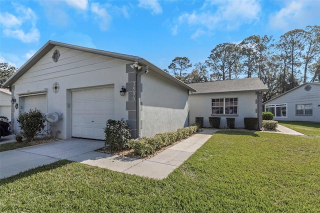 view of front of property with a front lawn, an attached garage, concrete driveway, and stucco siding