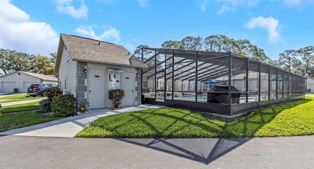 exterior space with a lanai, a yard, and an outdoor pool